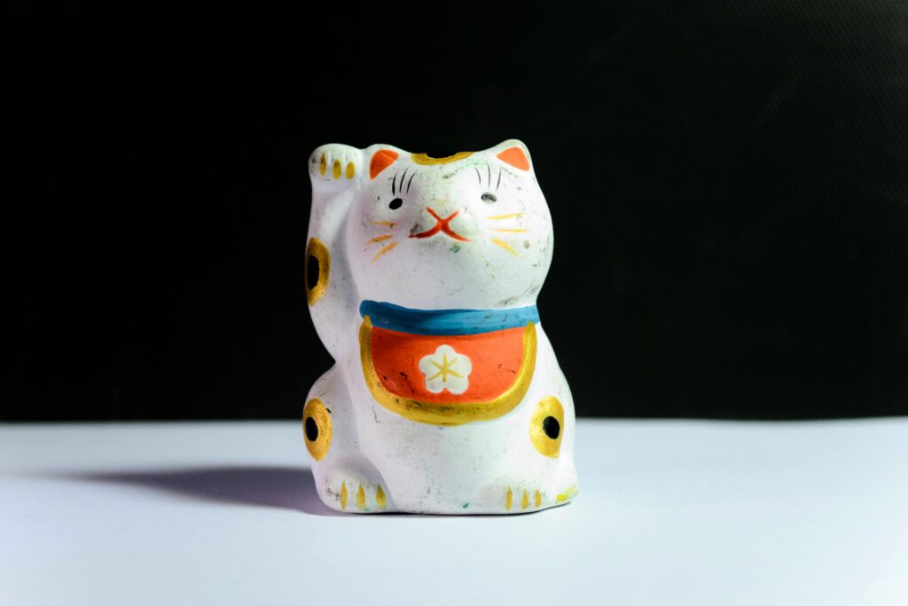 Cats in various cultural settings, from ancient Egyptian depictions to modern Japanese traditions.